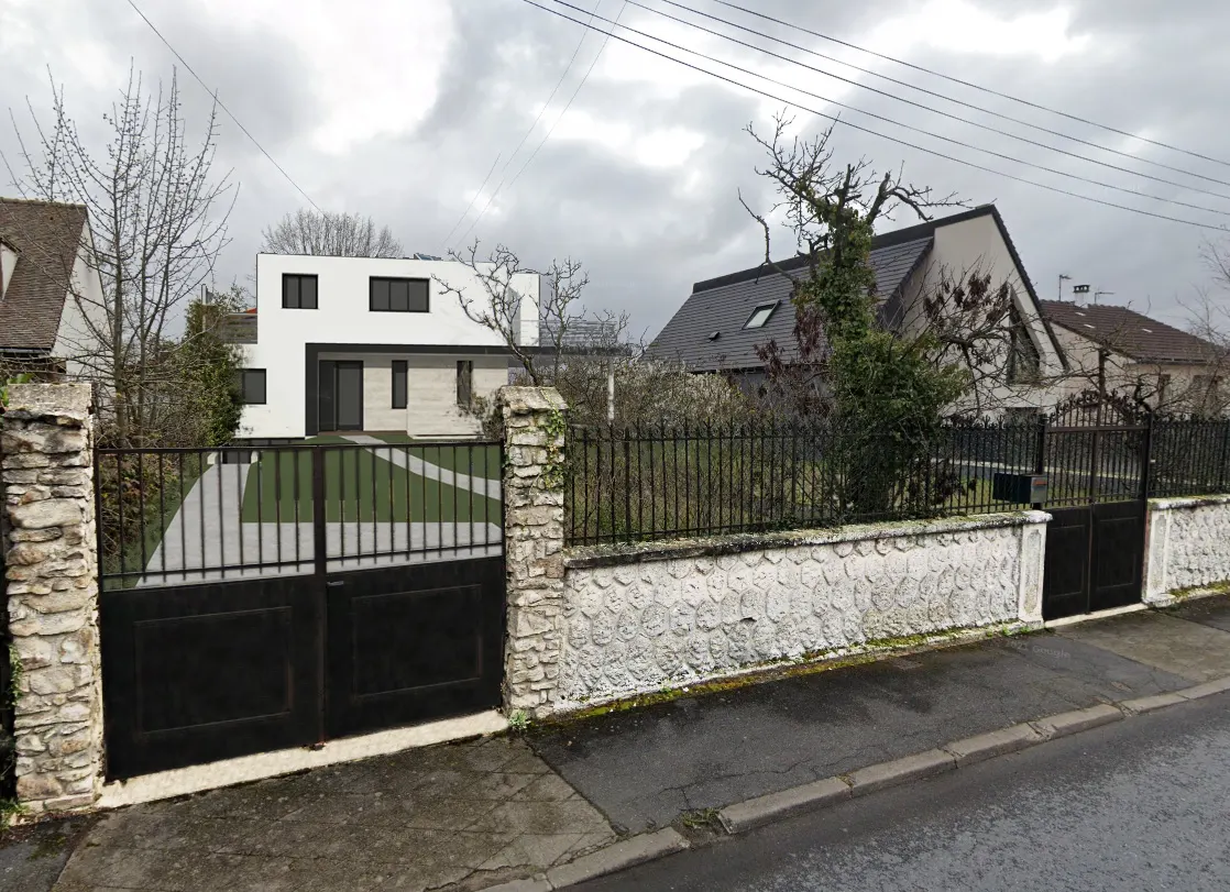 Même vue depuis la rue avec le projet : un volume blanc à toiture plate au fond de la parcelle, derrière le mur conservé.